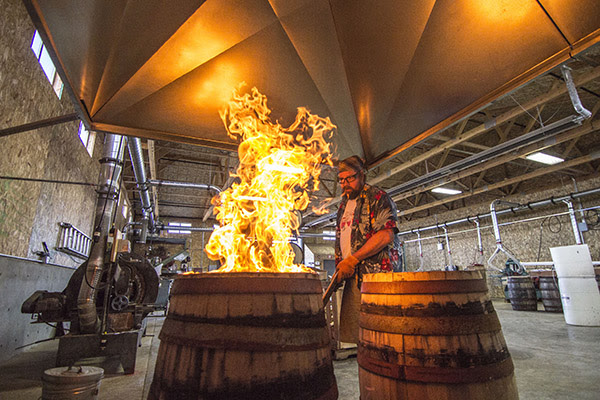 Rogue Cooper, Nate Lindquist, chars barrels at Rolling Thunder Barrel Works. (image courtesy of Rogue Ales)