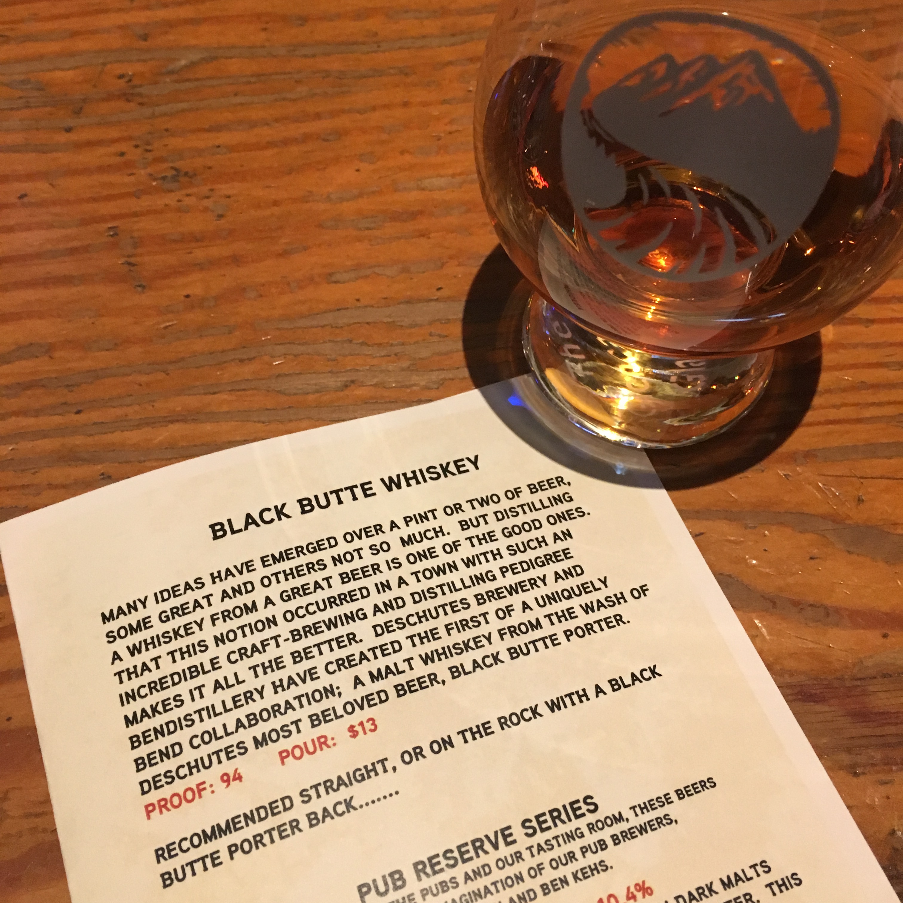 A neat pour of Bendistillery Black Butte Whiskey along with the menu description.