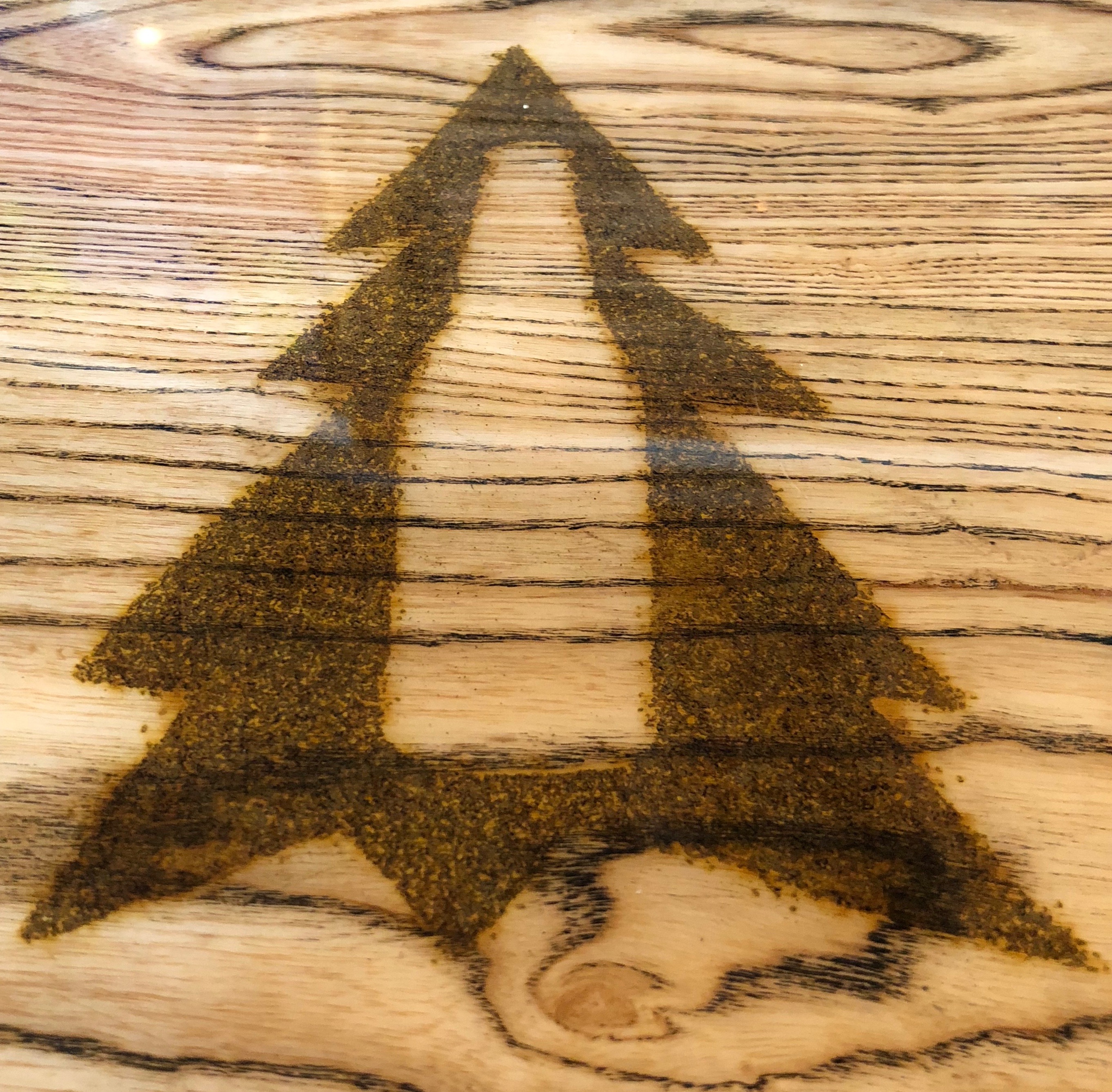 Backwoods Brewing's tree bottle logo is stamped into the bar at Backwoods In The Pearl.
