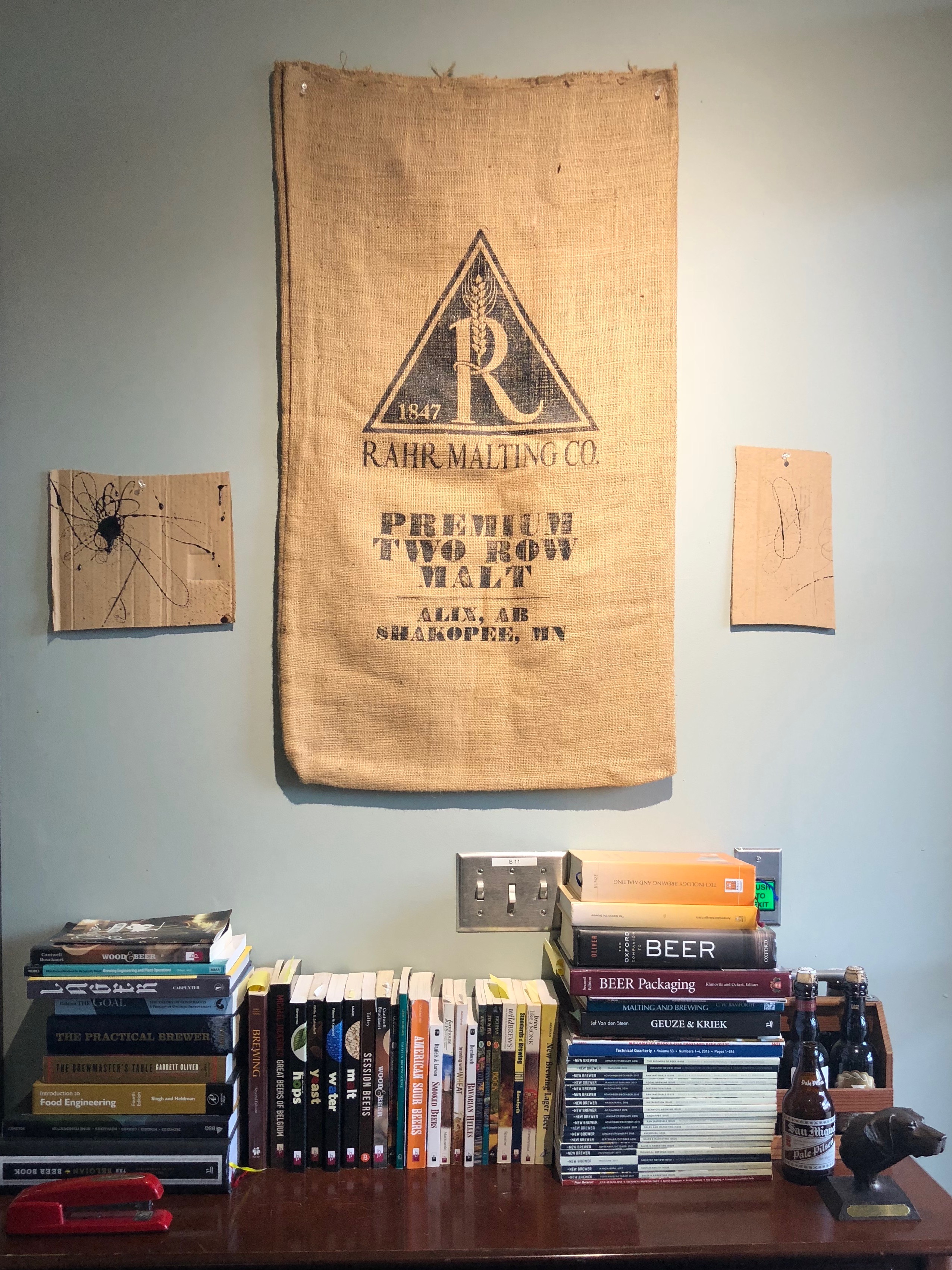 Rahr malt bags hang on the wall in an office area at pFriem Family Brewers.