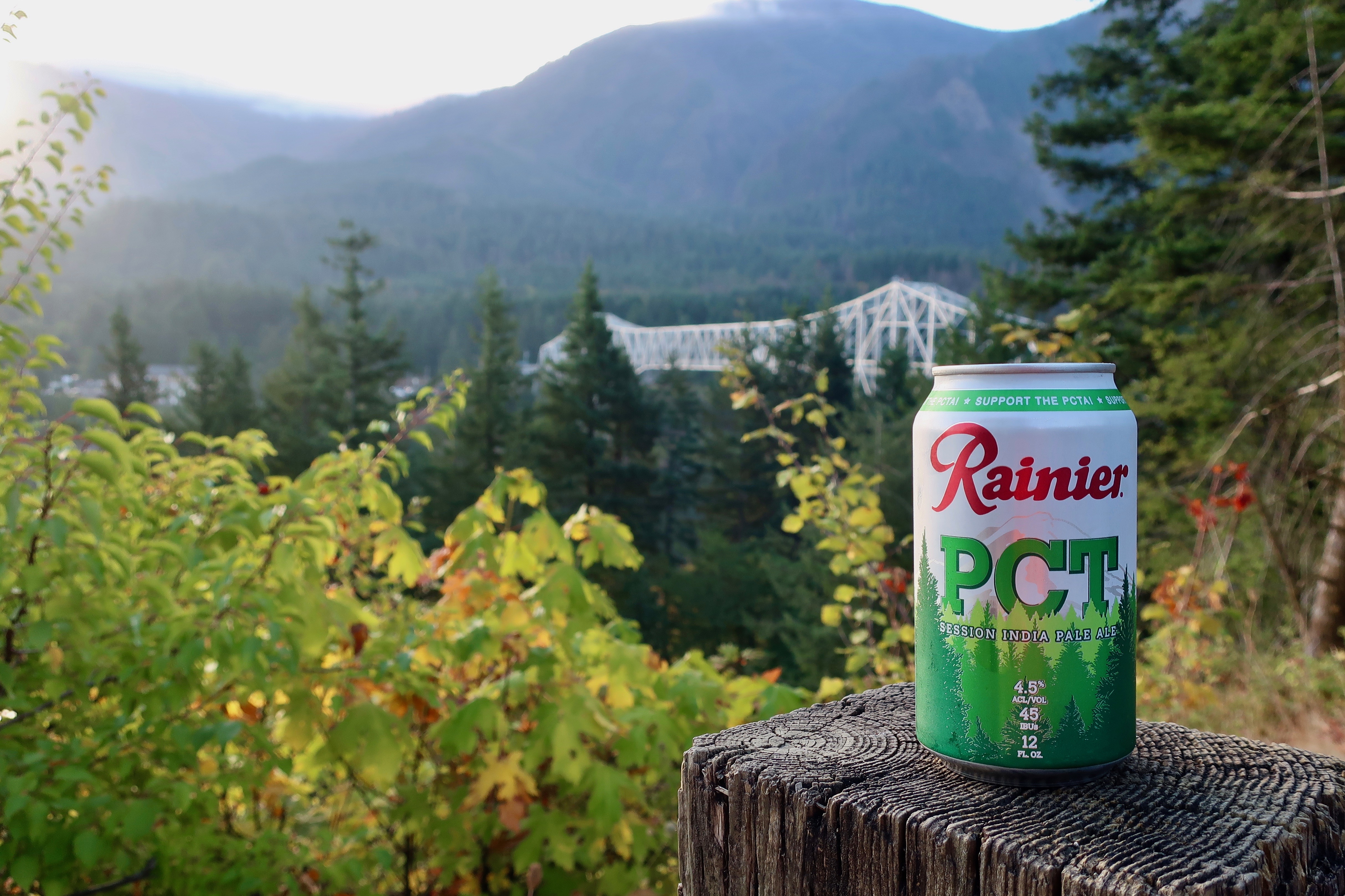 A can of Rainier PCT Session IPA with the famous Bridge of the Gods in the background.