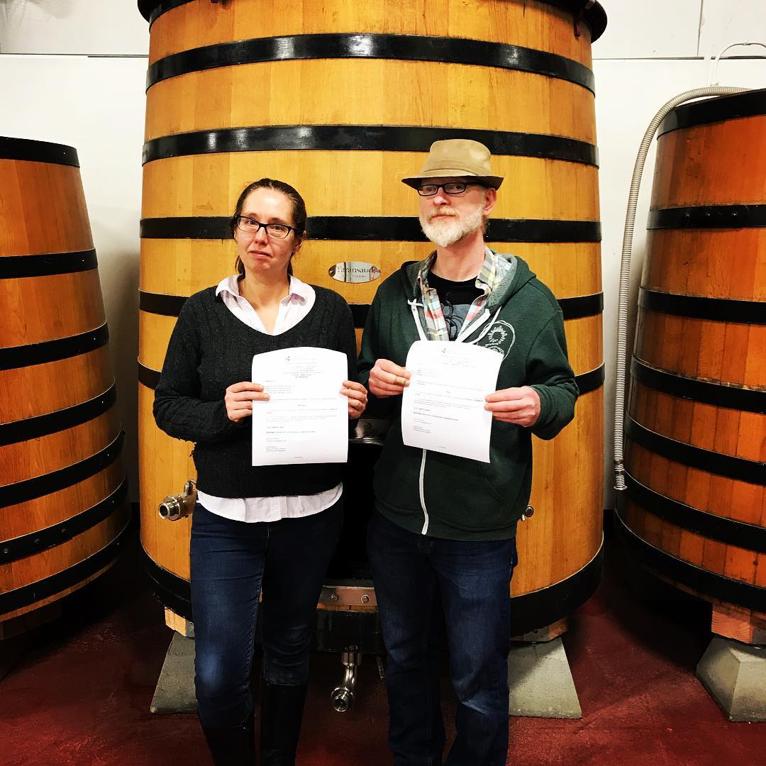Amber Watt and Ron Extract show off their state of Washington brewery and winery licenses on April 6, 2018. (image courtesy of Garden Path Fermentation)