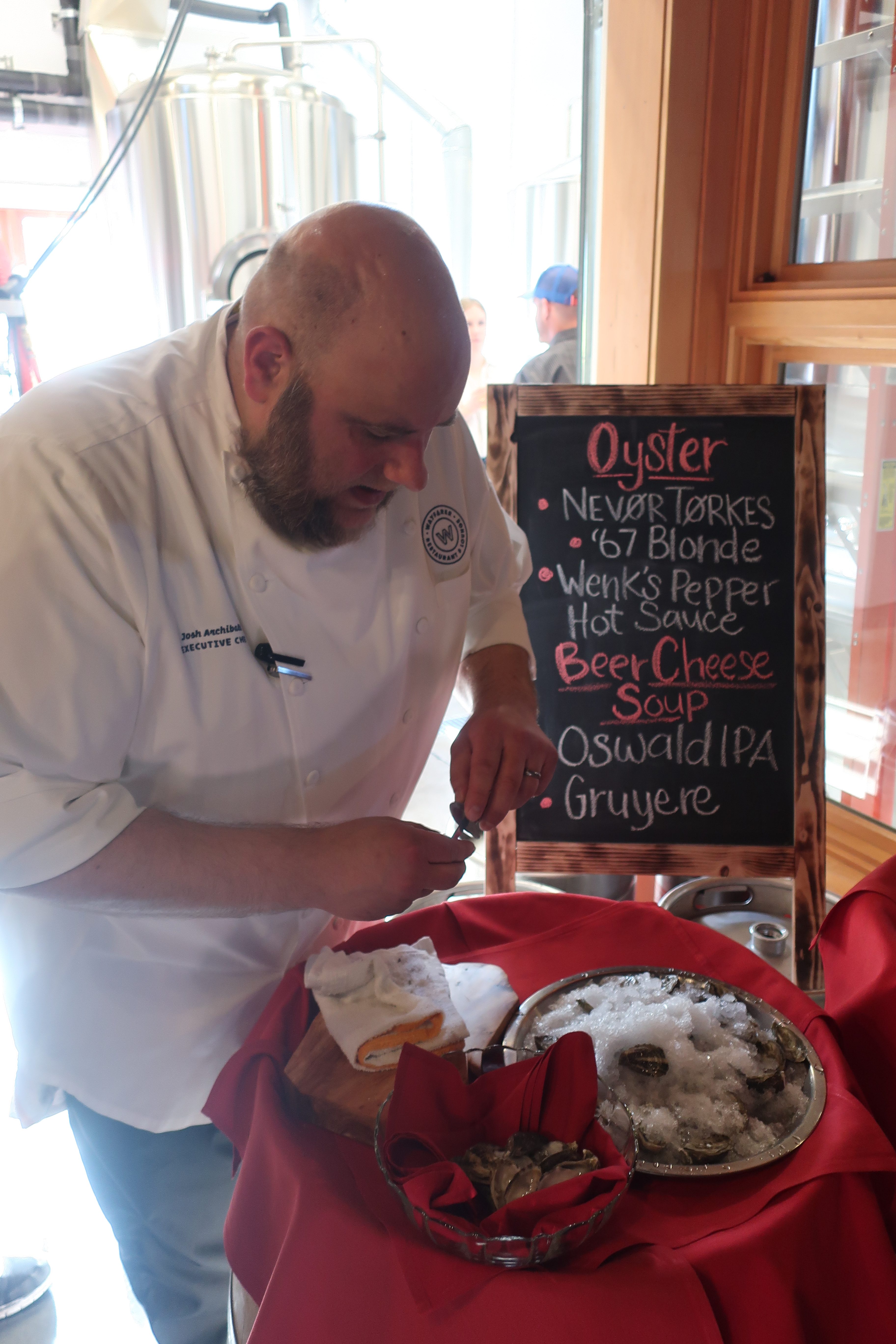 Executive Chef Josh Archibald from Wayfarer Restaurant shucking oysters at Public Coast Brewing.