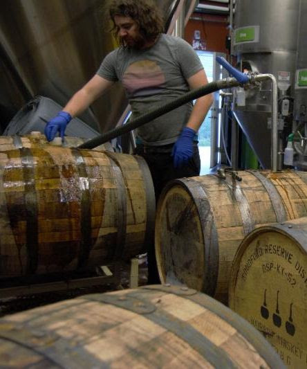 Oakshire’s Director of Brewing Operations, Dan Russo filling former whiskey barrels. (image courtesy of Oakshire Brewing)