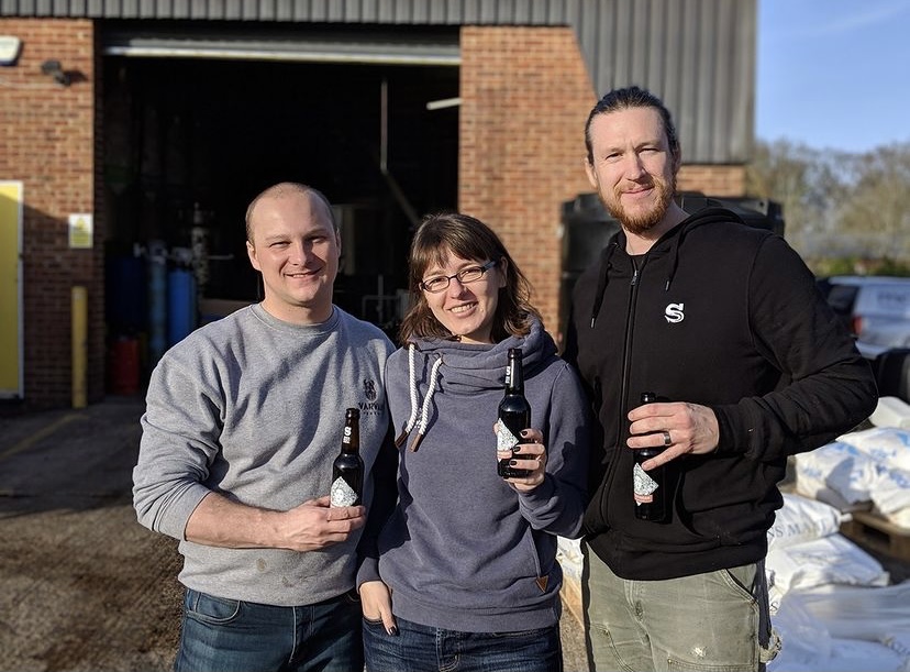 Kyle Larsen (right) and Lana Svitankova (center) a few years back while brewing a collaboration beer in Europe. (image courtesy of Kings & Daughters Brewery)