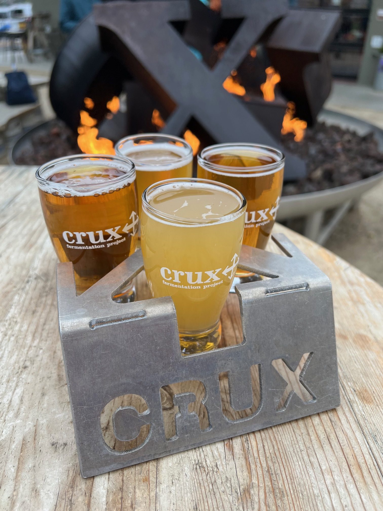 A taster tray at Crux Fermentation Project in front of the warm fire pit.