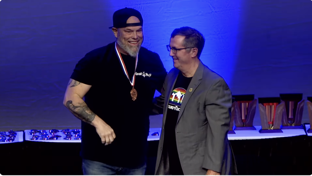 Mike Hunsaker accepting his first of two medals on stage at the awards ceremony of the 2024 Great American Beer Festival.