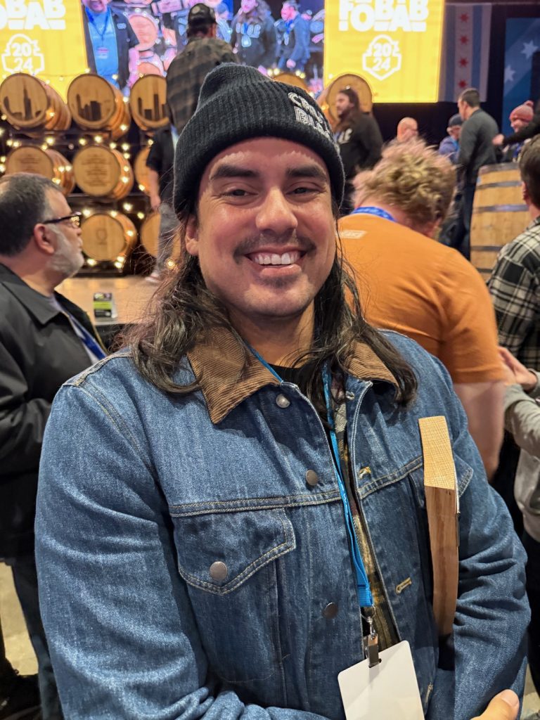 Jacob Sembrano, Head Brewer at Cruz Blanca Brewery, winning his first of two awards at the 2024 Festival of Wood & Barrel Aged Beer.